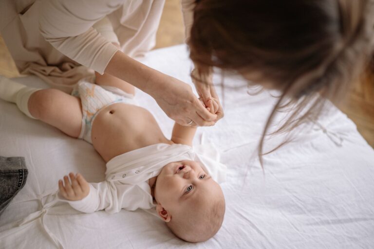 mother gently changes baby's onesie in a cozy home setting, nurturing and caring bond.