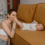 a tender moment between a mother and baby bonding on a cozy couch at home.