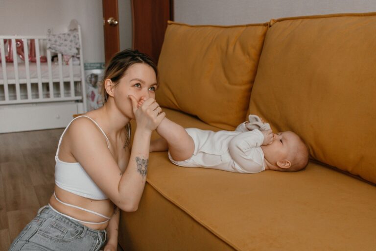 a tender moment between a mother and baby bonding on a cozy couch at home.