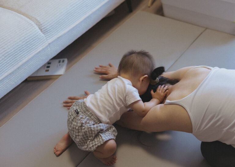 a mother and baby bonding on the floor indoors, showcasing love and intimacy.
