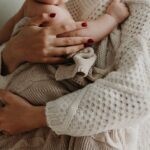 close-up of a mother holding her baby in warm knitwear, conveying love and togetherness.
