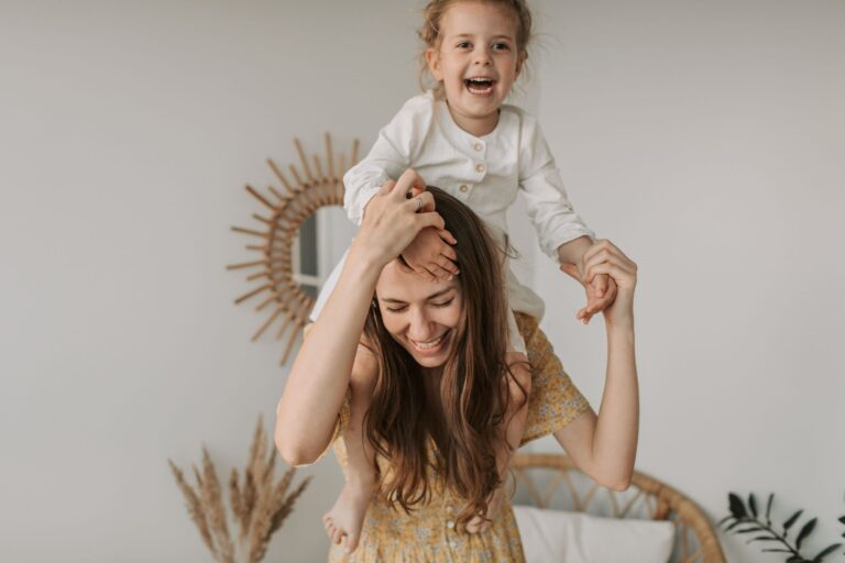 mother and daughter enjoying a playful moment indoors, smiling and happy.