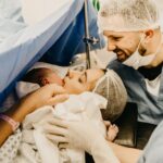 a cherished family moment as new parents welcome their baby in a hospital delivery room.
