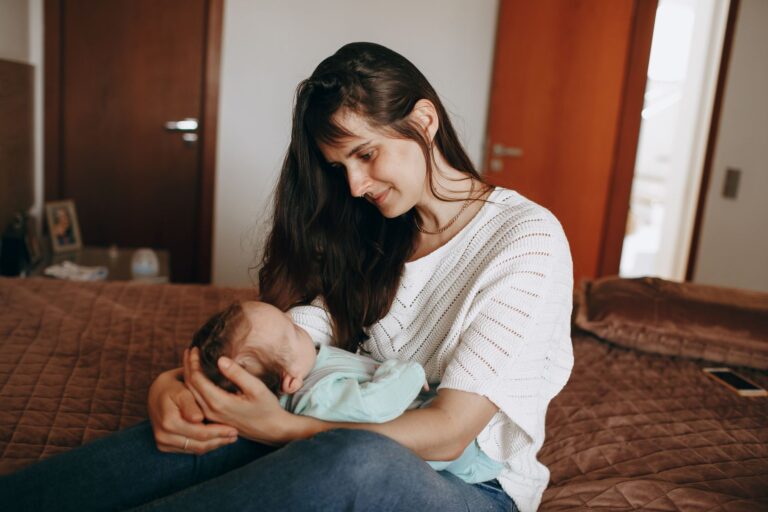 a tender moment captured between a mother and her baby in a cozy bedroom setting.