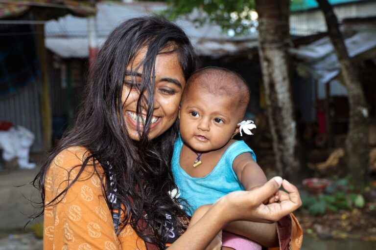 joyful portrait of a woman and baby smiling outside in manikganj, bangladesh.
