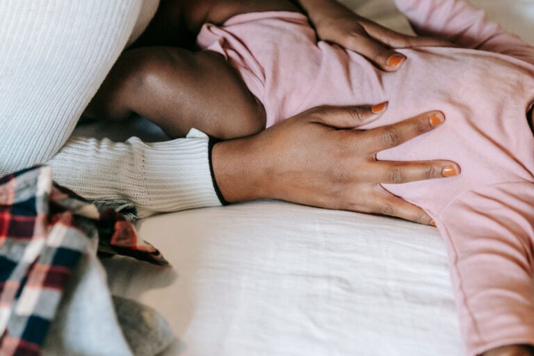 high angle of crop anonymous african american mother stroking small infant daughter