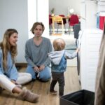 a mother and friend enjoy quality time with a toddler in a cozy home setting.