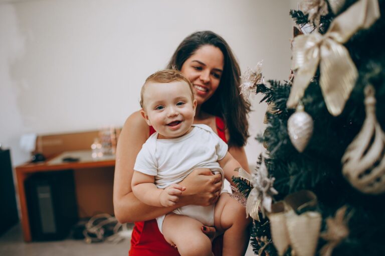 mother and child enjoying festive moments by a decorated christmas tree.