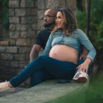 pregnant woman and partner relaxing outside, showcasing love and anticipation.