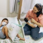 mother with baby and young child in a warm, nurturing nursery environment.
