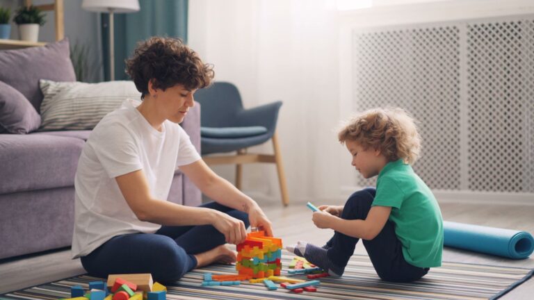 a woman and child engage in playful block building in a cozy living room setting.