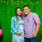 joyful couple at a maternity celebration with colorful balloons and decorations.