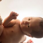 a sweet newborn baby wrapped in silk, sleeping peacefully in ho chi minh city studio.