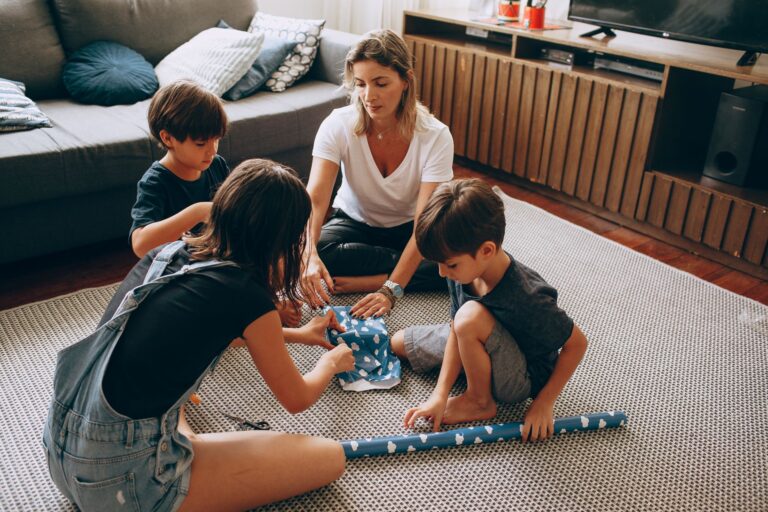 mother and children wrapping gifts together, enjoying quality family time indoors.