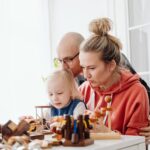 a family enjoys playing with wooden toys together indoors, promoting bonding and creativity.