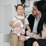 a joyful family scene with adopted child cuddling a stuffed toy indoor setting.
