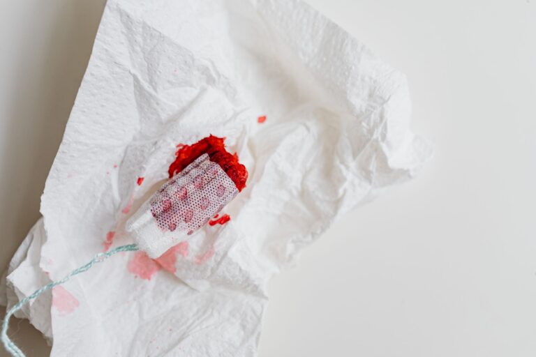 a used tampon with red stains on a crumpled white tissue for health awareness.