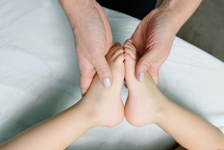 adult hands gently massaging baby feet. perfect representation of care and relaxation.