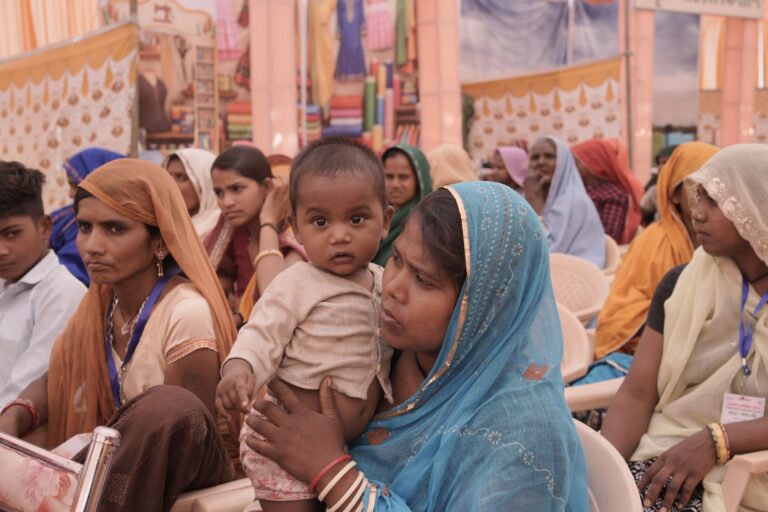 a vibrant scene of rajasthani mothers and children at a community gathering, showcasing cultural attire.