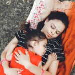 mother and daughter lying on blanket outdoors, showcasing love and connection.