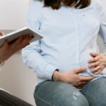 pregnant woman attending a healthcare consultation, showcasing doctor-patient interaction.