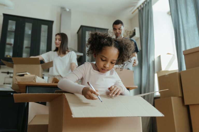 a family joyfully unpacking boxes in their new kitchen, marking a fresh start.
