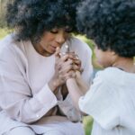 a heartwarming moment between a mother and daughter holding hands outdoors.