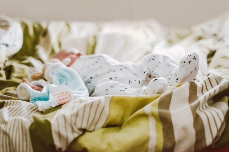 adorable baby sleeping peacefully in a cozy bed with soft blankets, capturing warmth and innocence.