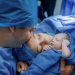 a touching moment of a newborn with parents in a hospital after delivery.
