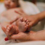 close-up of a baby's feet during a bath, with an adult's hands gently holding them.