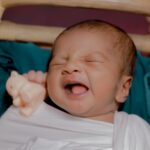adorable indian newborn sleeping in a cradle with a toy, showcasing innocence and comfort.