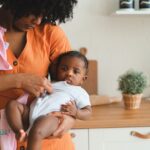 a loving mother holding her baby in a cozy kitchen, showcasing warmth and care.