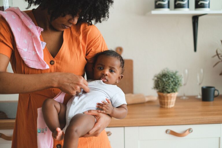 a loving mother holding her baby in a cozy kitchen, showcasing warmth and care.