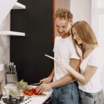 couple happily preparing a healthy meal together in a modern kitchen setting.