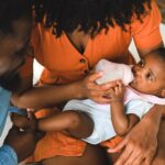 parents lovingly feeding their baby with a bottle. a warm family moment captured indoors.