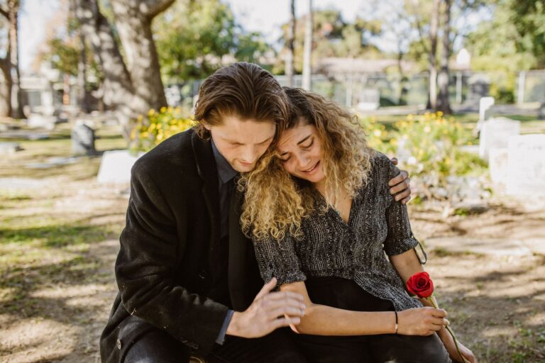 a comforting embrace in a serene graveyard captures grief and support.