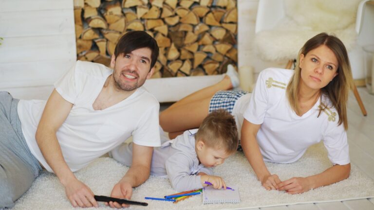 family lounging indoors with child drawing pencils, enjoying relaxation and togetherness.
