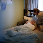 a mother caring for her sick child in a cozy bedroom setting, emphasizing love and comfort.