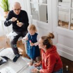 a family bonding while blowing bubbles together indoors, capturing a joyful moment.