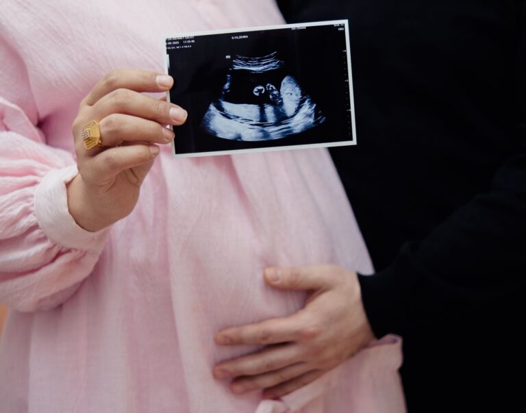 pregnant couple holding ultrasound image, celebrating new life and pregnancy journey.