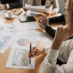 business professionals reviewing charts and graphs during a meeting in office setting.