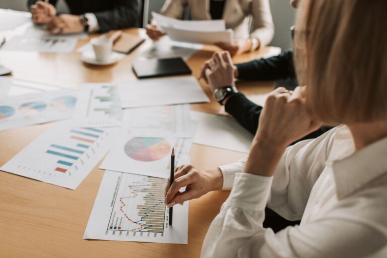 business professionals reviewing charts and graphs during a meeting in office setting.