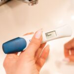 close-up of a negative pregnancy test displayed by a woman's hand.