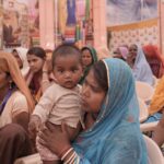 a vibrant scene of rajasthani mothers and children at a community gathering, showcasing cultural attire.