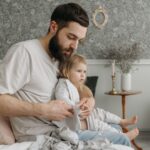 father helping daughter get dressed in a cozy bedroom environment, highlighting nurturing parenting moments.
