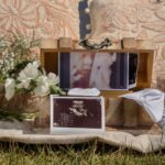 a vintage box with ultrasound photos, baby items, and floral decor captures a heartfelt gender reveal moment.