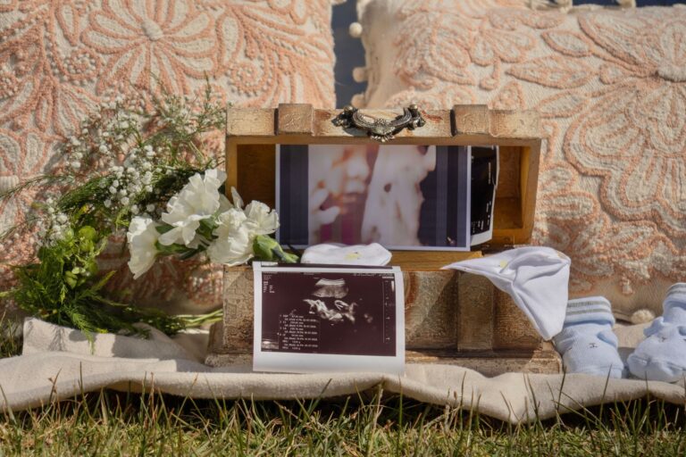 a vintage box with ultrasound photos, baby items, and floral decor captures a heartfelt gender reveal moment.