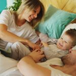 a cheerful family enjoying a playful morning in bed, sharing laughter and happiness.