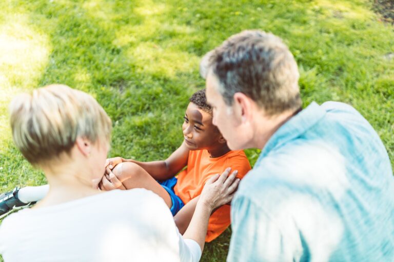 a family moment with a child and adults bonding outdoors during a sunny day.