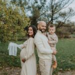 pregnant mother, father, and son in a serene outdoor setting, celebrating family joy.